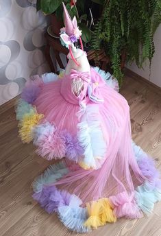 a dress made out of tulle and feathers with a unicorn hat on the top