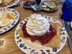 two plates with desserts on them sitting on a table next to silverware and utensils