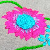 a pink flower with green stems on a white background is stitched onto the side of a piece of fabric