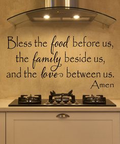 a stove top with a quote on the wall above it that says,'bless the food before us, the family beside us, and the love between us, amen