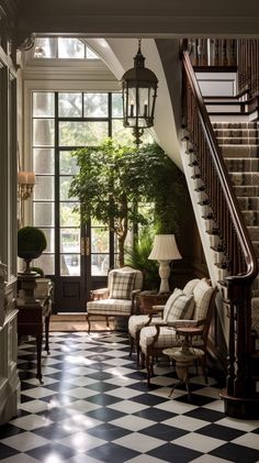 an elegant entryway with black and white checkered flooring, chandelier, chair, table lamp and potted tree