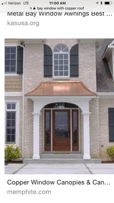 a large brick house with black shutters on the front door and brown trim around the windows