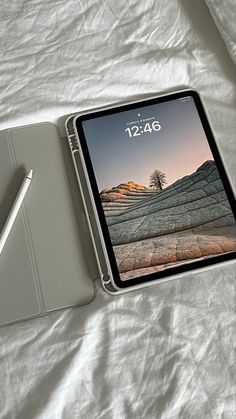 an ipad with a pen sitting on top of it