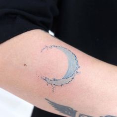 a person with a tattoo on their arm that has the moon and arrow drawn on it