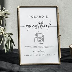 a polaroid sign sitting next to a potted plant