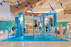 the inside of a clothing store with blue and green accents