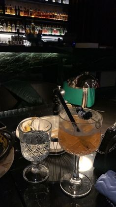 a table topped with two glasses filled with drinks