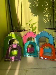 three brightly colored dog houses sitting next to each other in front of a green wall