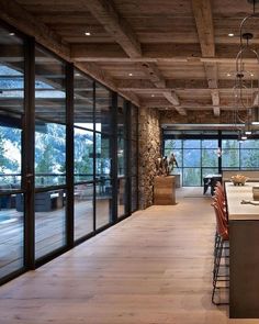 an instagram photo of a kitchen and living room with glass doors on the walls