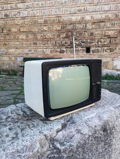 an old television sitting on top of a rock