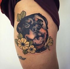 a woman's thigh with a dog and flowers on it