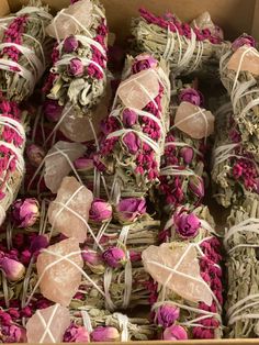 a box filled with lots of pink flowers next to white string wrapped in twine