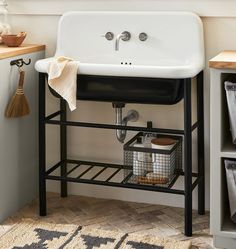 a black and white sink sitting under a window next to a shelf with utensils