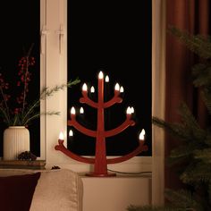 a lighted christmas tree sitting in front of a window