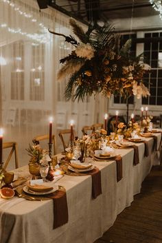 a long table is set with candles, plates and other items for an elegant dinner