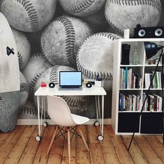 a room with a desk, bookshelf and baseballs on the wall