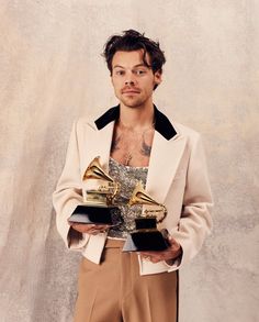 a man holding two awards in his hands