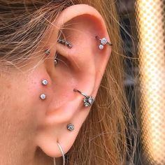 a close up of a person with ear piercings on their ears and behind the ear