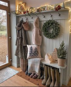 the entryway is decorated for christmas with wreaths, stockings and boots on display