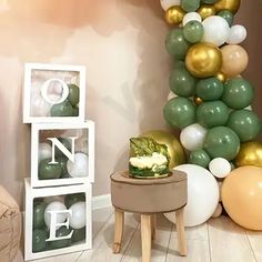 a room filled with balloons and furniture in front of a tall green balloon tree on the wall