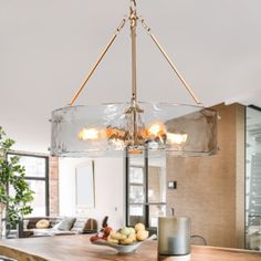 a chandelier hanging over a wooden table in a room with lots of windows