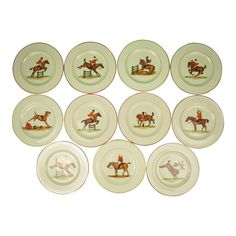 twelve plates with horses and jockeys painted on the front, set against a white background