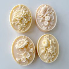 four carved soap molds with flowers on them