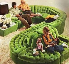 a group of people sitting on top of green couches