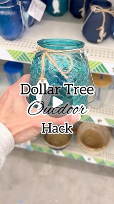 a person holding a jar with the words dollar tree outdoor hack in front of it