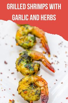 grilled shrimps with garlic and herbs on a white platter text reads grilled shrimps with garlic and herbs