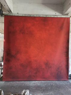 a large red piece of art hanging on the side of a wall in a room