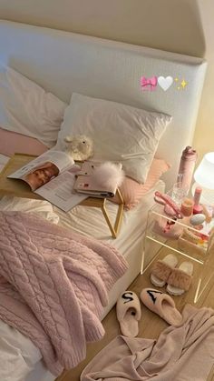 there is a bed with pink blankets and slippers on the floor next to it