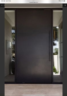 an image of a black door in the middle of a room with glass doors on both sides