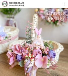 a basket filled with pink flowers on top of a wooden table next to other baskets