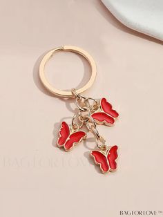 a keychain with two red hearts hanging from it's side on top of a white surface