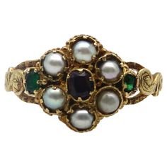 Here at Kirsten’s Corner, we have a sweet spot for these early Victorian flower rings. This 15k gold ring is reminiscent of a Forget-Me-Not flower, a popular motif in the Victorian era. The pearl flower petals in the ring represent tears and capture the romance in our hearts. A central garnet sits delicately amidst a lacy background, while two Old Emerald Cut emeralds add a pop of green to each side of the flower. Each stone is prong set into an early Victorian setting that was traditional for these types of rings. Along the sides is scrolling foliate, hand detailed to look like leaves. A lovely engraving goes all the way around the band of the ring, even detailing the edges of the band. Circa 1850, this is a very old ring that conveys sentimentality and everlasting love. The garnet measur 16th Century Jewelry, Edwardian Wedding Ring, Antique Emerald Engagement Ring, Victorian Wedding Ring, Green Engagement Rings, Antique Rings Victorian, Victorian Style Rings, Avon Rings, Art Nouveau Ring