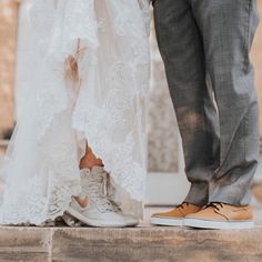 the bride and groom are holding hands in front of each other while standing on steps