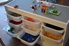 a toy kitchen with legos on the counter and food in bins under it