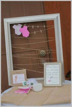 a table topped with a white frame covered in paper and clothes hanging from it's sides