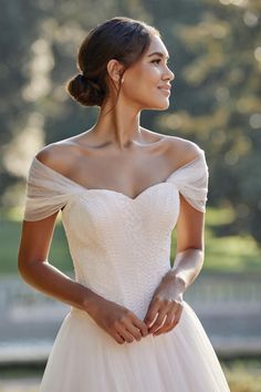 a woman in a wedding dress is posing for the camera with her hands on her hips