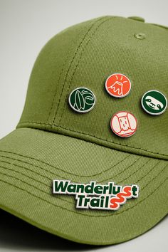 a green hat with several stickers on the front and side of it that says wanderlust trail