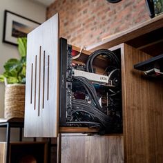 the inside of a computer case with wires and cables in it, sitting on top of a wooden cabinet