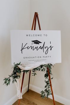 a sign that says welcome to kennely's graduation party on top of a wooden easel