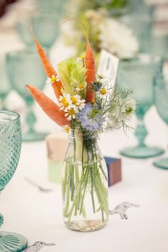 a vase filled with lots of different types of flowers on top of a white table