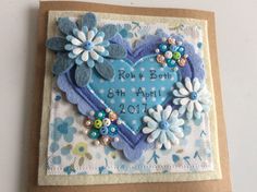 a blue heart shaped card with flowers on it