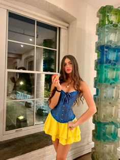 a woman in a blue and yellow corset standing next to a stack of plastic bottles