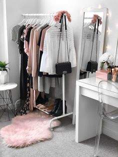 a white dressing room with clothes on hangers