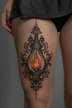 a woman's thigh with a burning candle tattoo on it