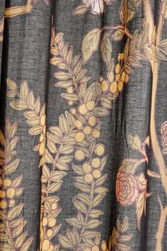 a close up view of a curtain with flowers and leaves printed on it in grey