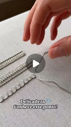 someone is stitching together some pins on a piece of fabric with their thumbnails